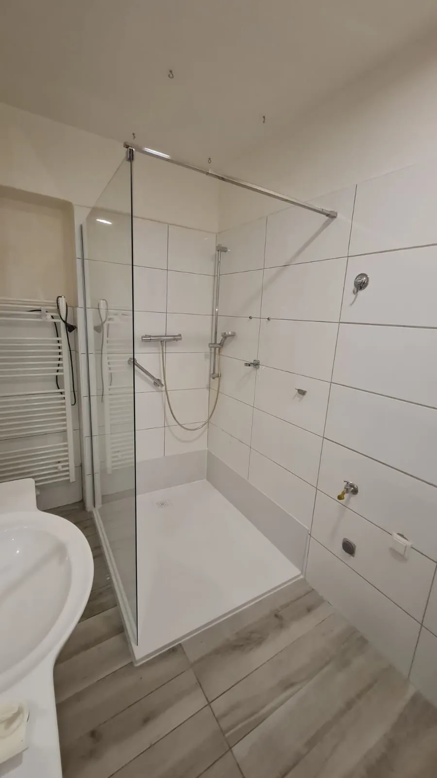 Fertig umgebautes, helles Bad mit bodengleicher Glastür-Dusche von Dimen Deal
